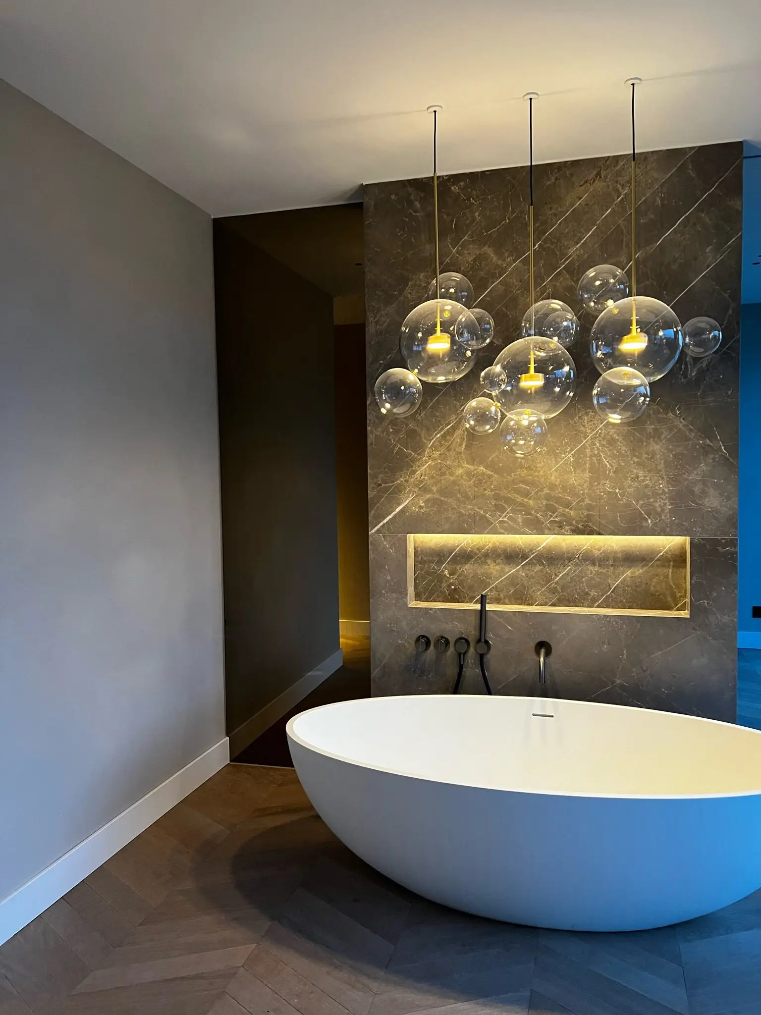 Gerenoveerde badkamer met vrijstaand bad en warme verlichting
