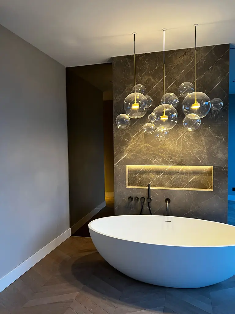 Gerenoveerde badkamer met vrijstaand bad en warme verlichting