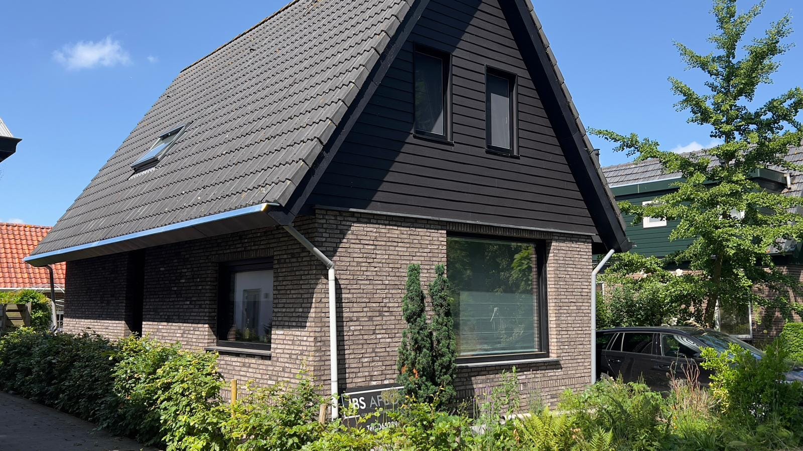 Vooraanzicht van het gerenoveerde woonhuis met steenstrips, Andijk