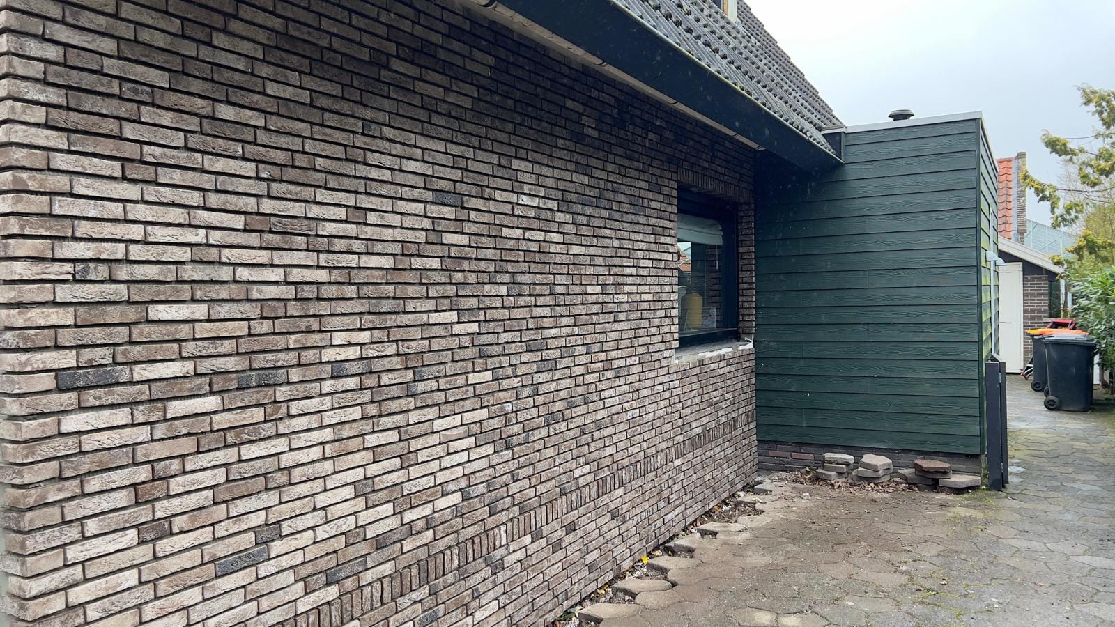 Zijgevel met steenstrips en donkere houten topgevel, woonhuis Andijk