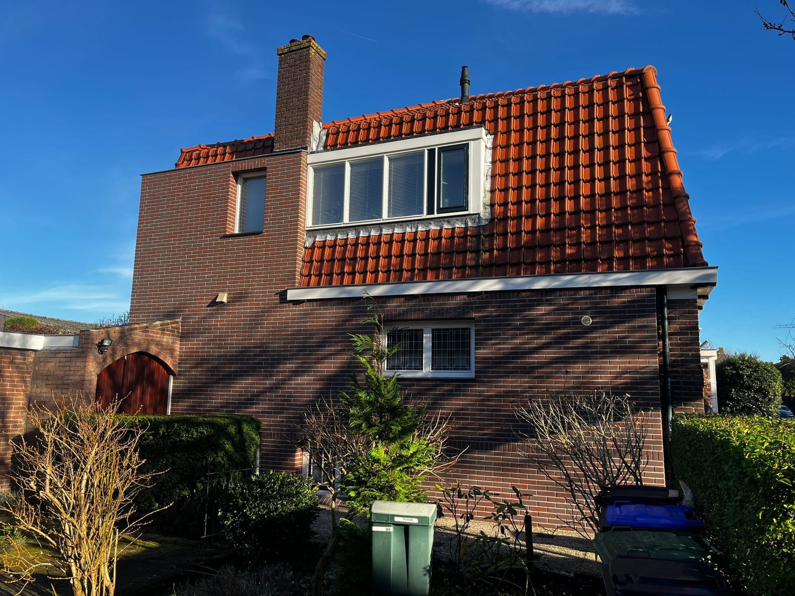 Gerenoveerde gevel met steenstrips onder strakblauwe lucht, woonhuis Bussum (ná-foto)