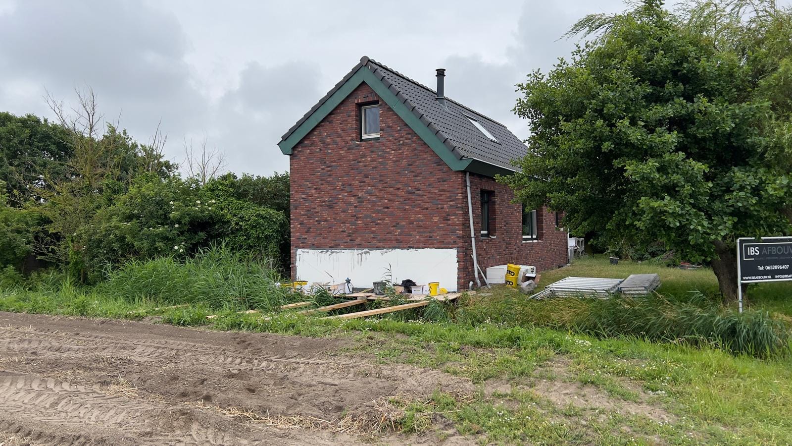Gerenoveerd woonhuis met steenstrips gezien vanaf het erf, Callantsoog