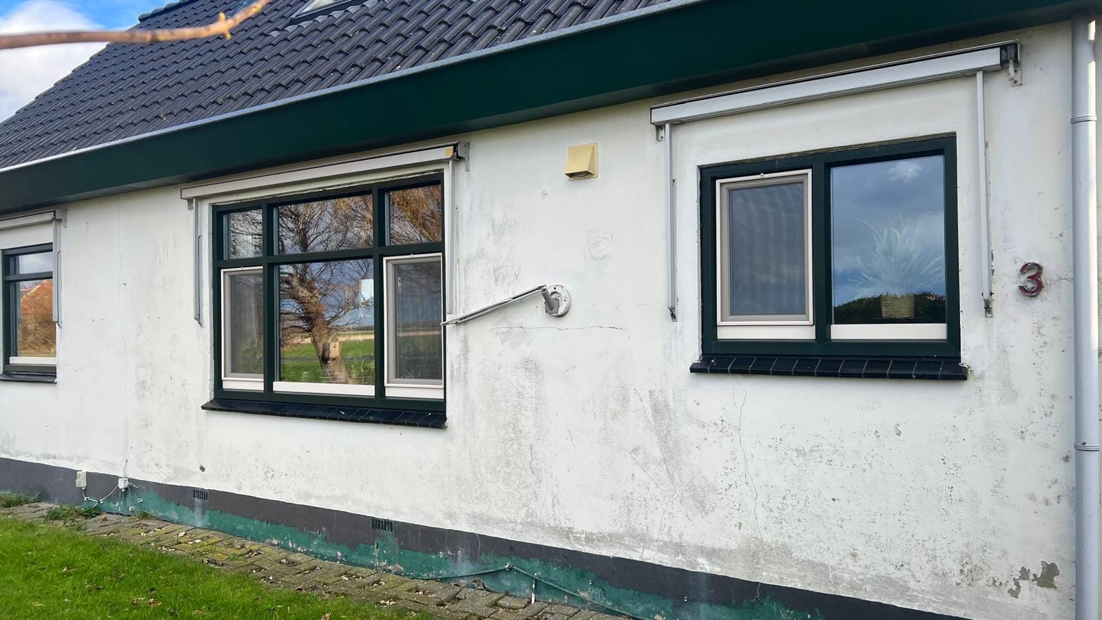 Verweerde witte stucgevel vóór de renovatie, woonhuis Callantsoog (vóór-foto)