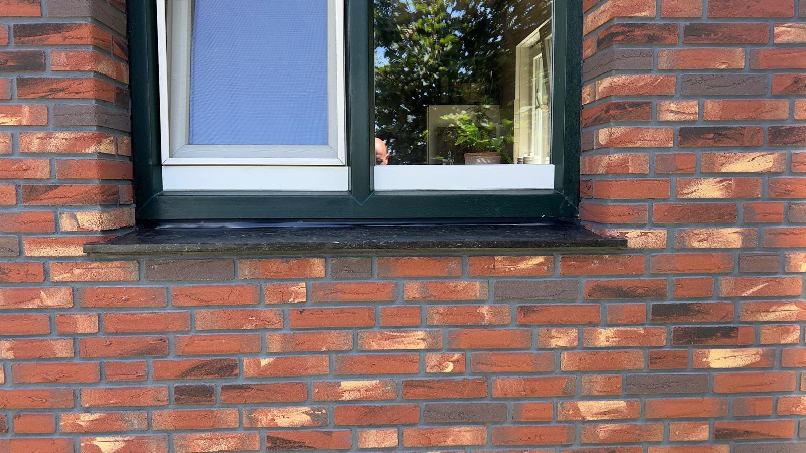 Close-up van roodbruine steenstrips rond het kozijn, woonhuis Callantsoog