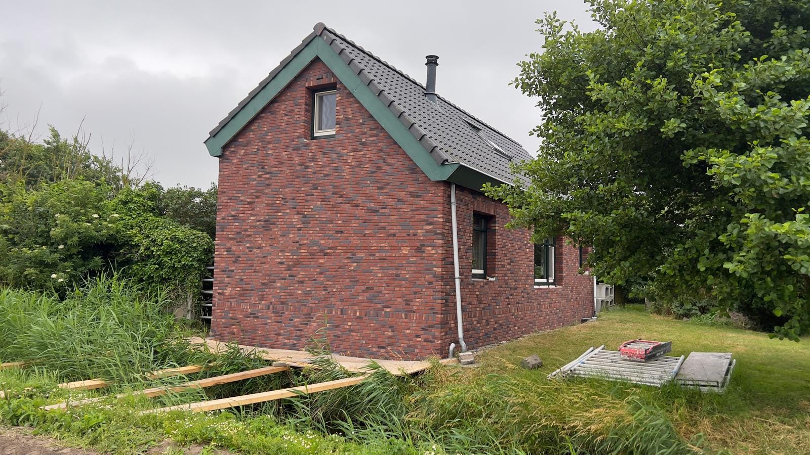 Vrijstaand woonhuis met roodbruine steenstrips in landelijke omgeving, Callantsoog