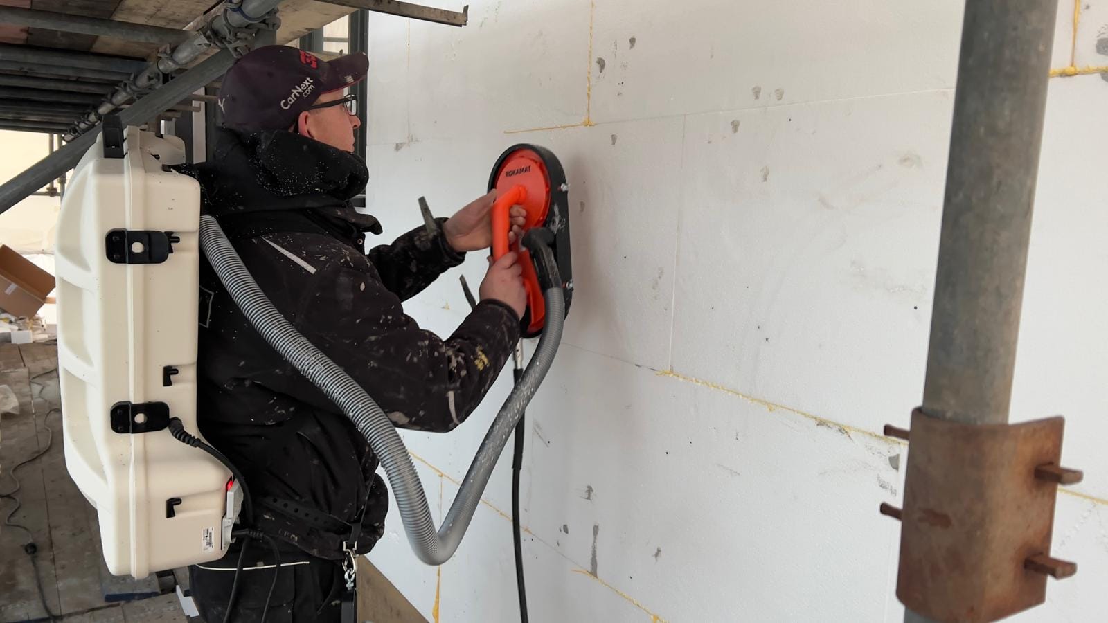 Vakman zaagt steenstrips op maat tijdens de montage, Heiloo