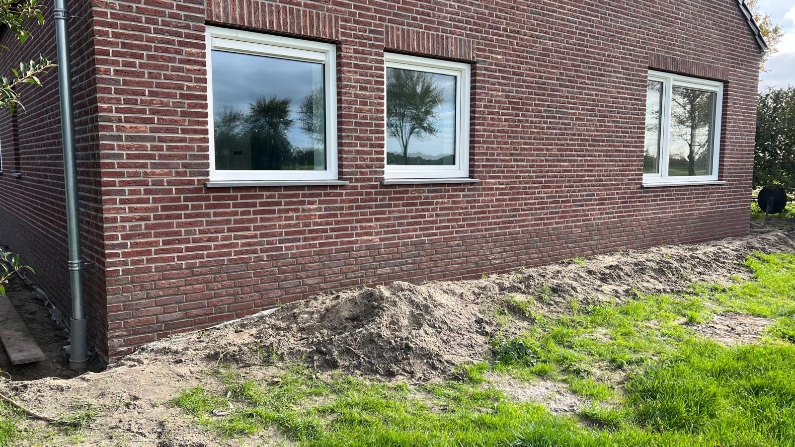 Hoekaanzicht van nieuwbouwgevel met rode steenstrips, woonhuis Langedijk