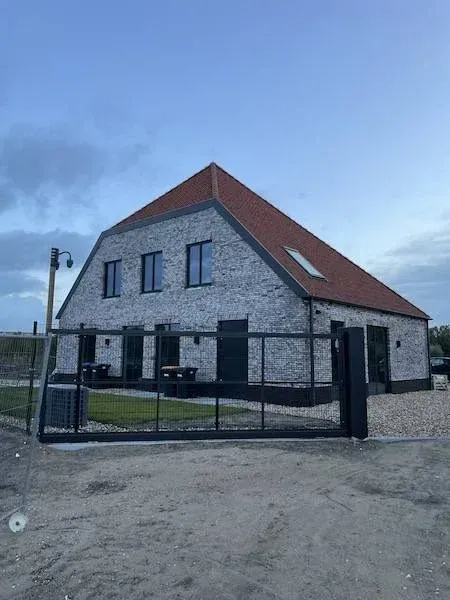 Stolpboerderij met witgenuanceerde steenstrips op betonnen casco