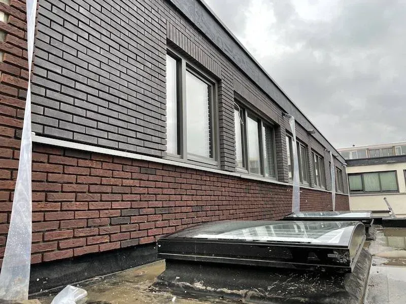 Geveldetail met twee kleuren steenstrips en raampartij, project Utrecht