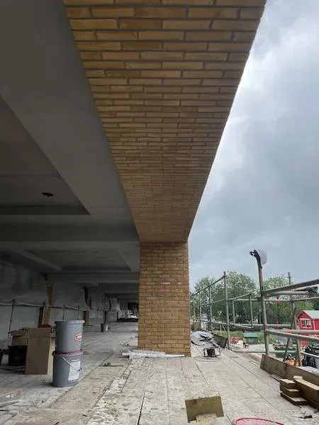 Kolom en plafond met gele steenstrips in aanbouw, winkelcentrum Haarlem