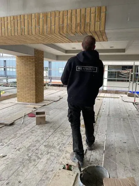 Montage van steenstrips aan het luifelplafond, winkelcentrum Haarlem