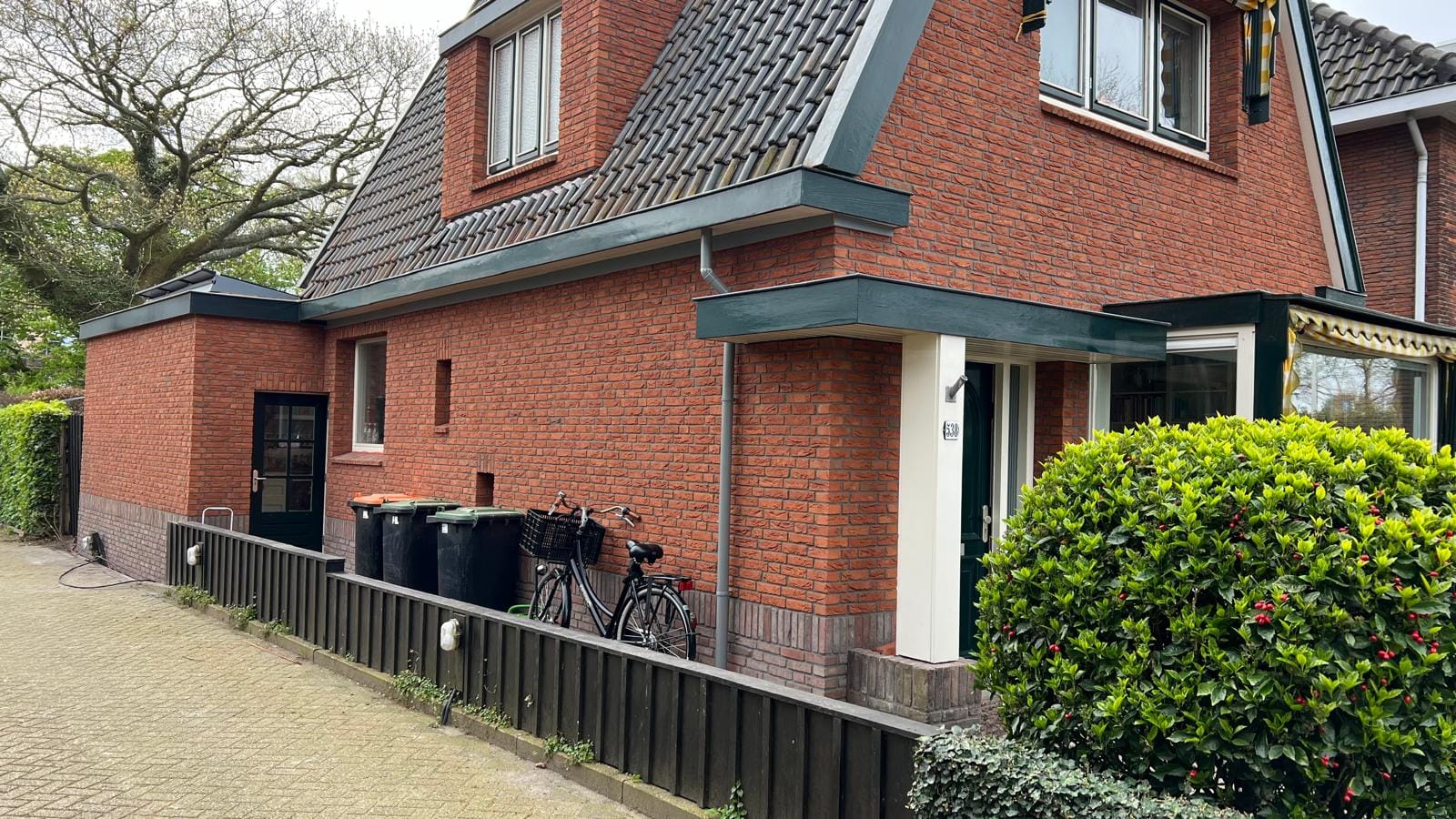 Zijgevel met rode steenstrips van het gerenoveerde woonhuis, Heiloo